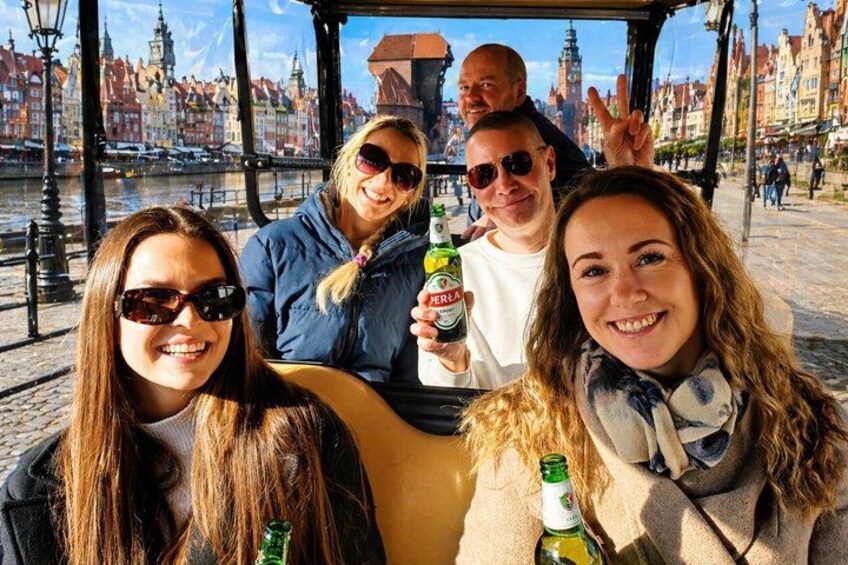 Un grupo de personas en un bote en un pueblo histórico europeo, con edificios y un río. 1