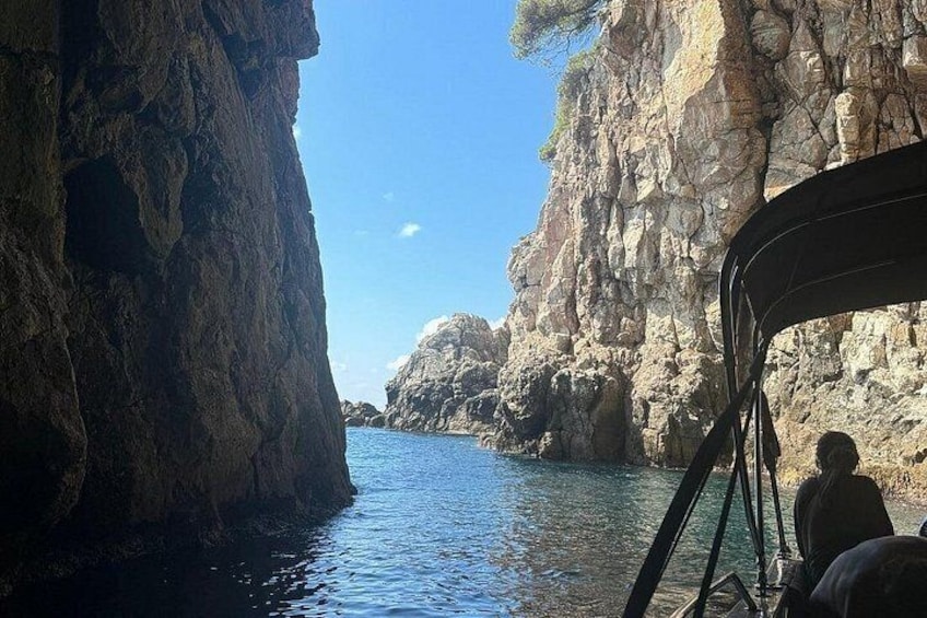 A boat navigating through a narrow waterway flanked by rocky cliffs. 2