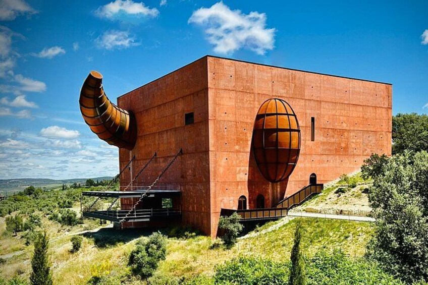 A modern building with a large spherical window and a curved chimney. 1