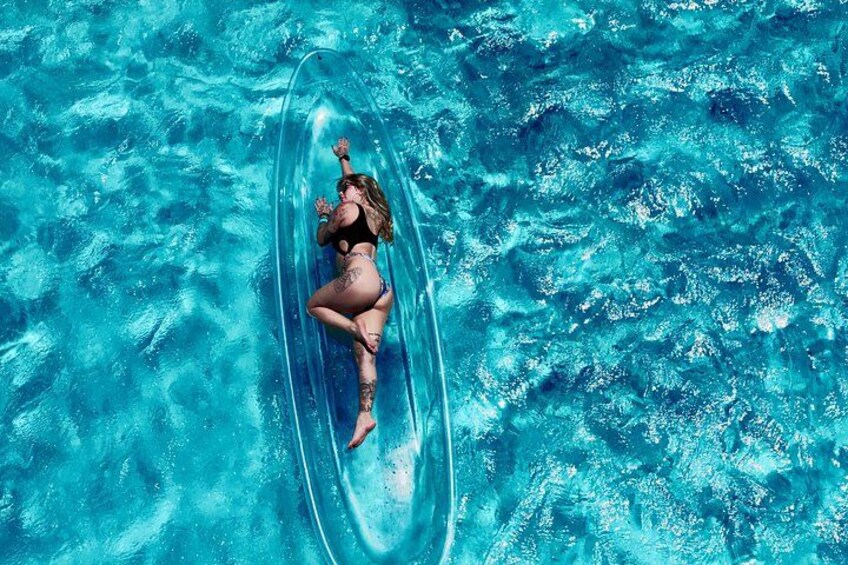 A person floating on a clear blue water surface. 2