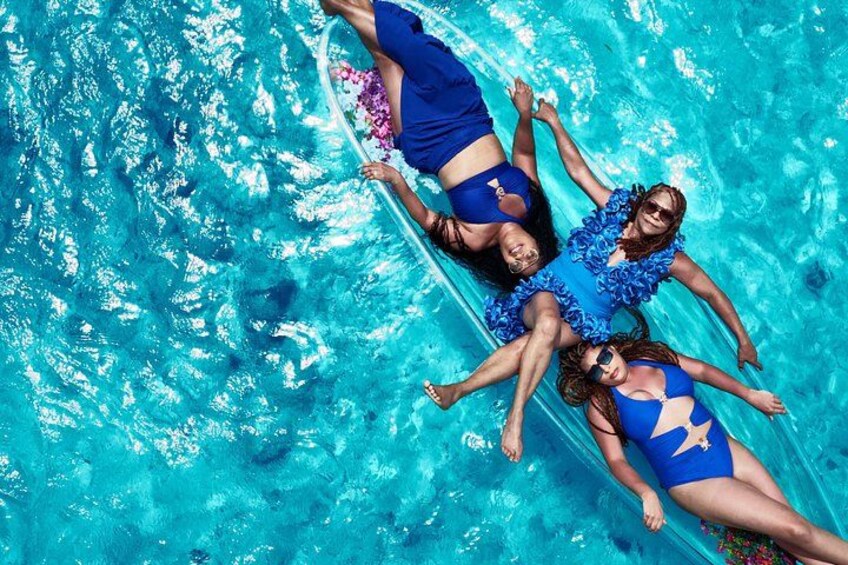 Three people floating in a pool. 3