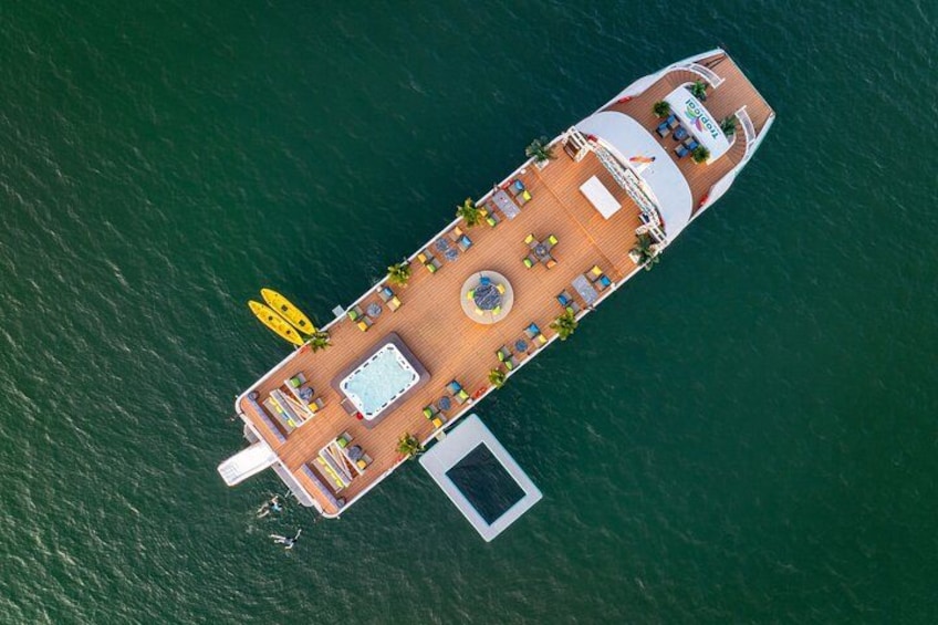 An aerial view of a cruise ship with a swimming pool, sun loungers, and a lifeboat. 2