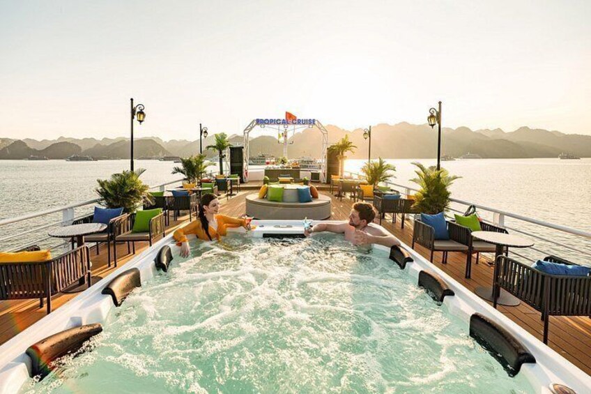 A hot tub on a deck with a view of the water and mountains in the background. 2