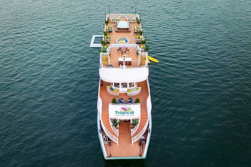 A large cruise ship with a Tropical logo, multiple decks, and outdoor seating areas. 2