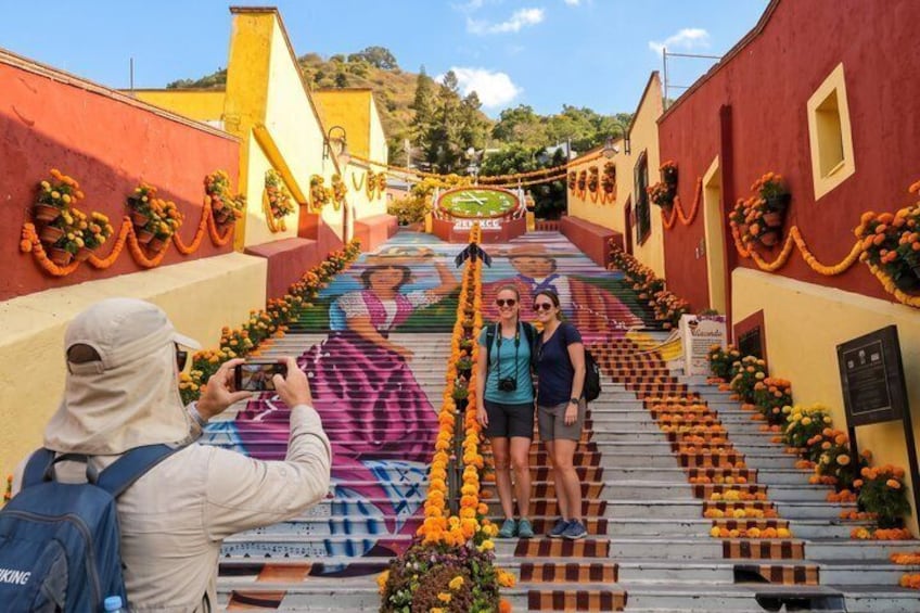 A staircase decorated with flowers and a mural. 2