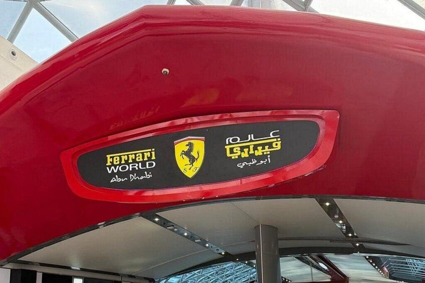 Un vehículo rojo con el logotipo de Ferrari World y texto en árabe. 2