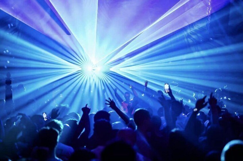 A crowd of people at a concert with a central light source. 2