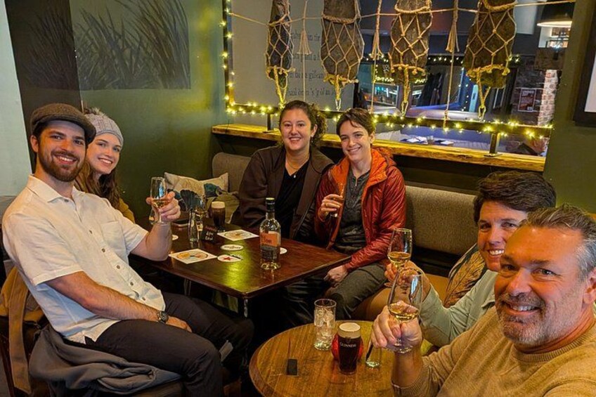 En gruppe mennesker sidder ved et træbord i en restaurant med maritim indretning. 2