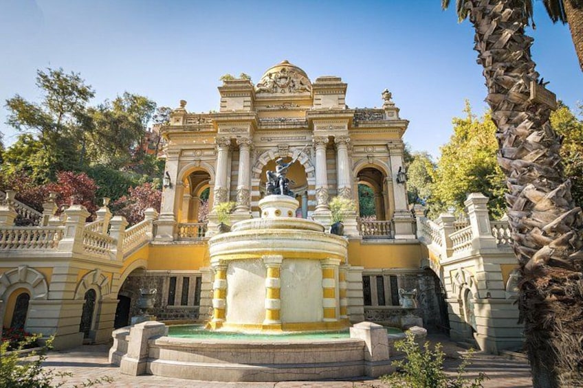 A historic building with ornate architecture, a central fountain, and surrounding greenery. 5