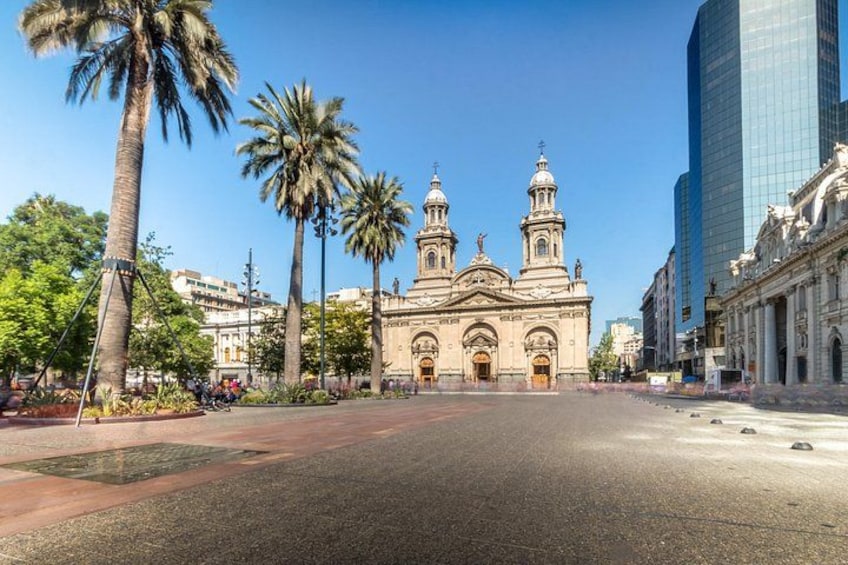 A street with palm trees, a historic building with domes, and modern high-rise buildings. 3