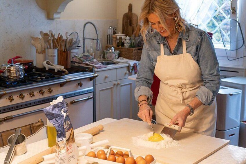 En person i ett kök som lagar mat, med ägg på en skärbräda, en kavel och en skål med ägg. 5