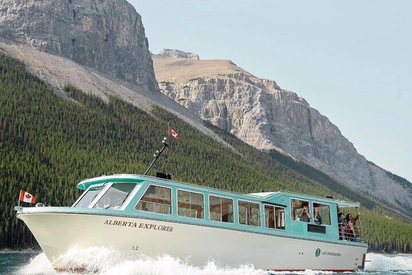 En båd ved navn 'ALBERTA EXPLORER' med passagerer sejler på søen, med bjerge i baggrunden. 1