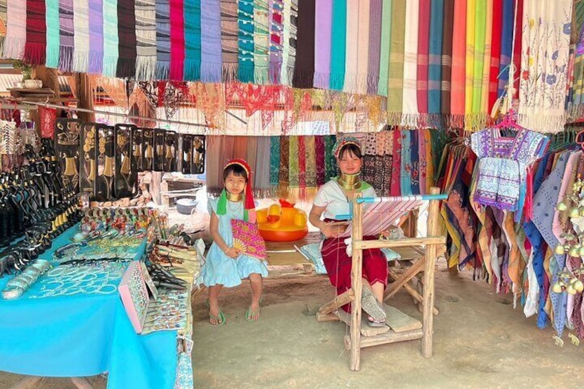 Un puesto de mercado con textiles y joyería de colores. 2