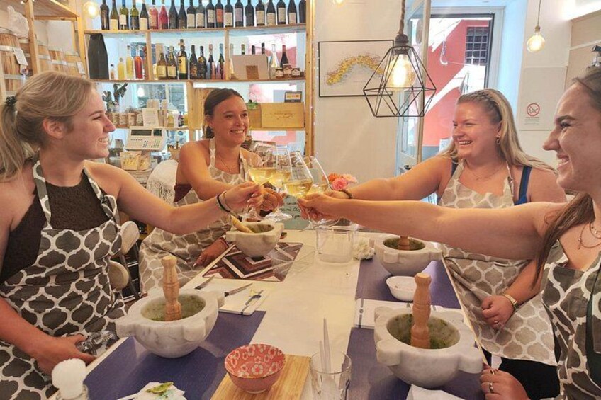 Een groep mensen proost met wijnfluiten in een restaurant, met een wijnrek op de achtergrond. 5