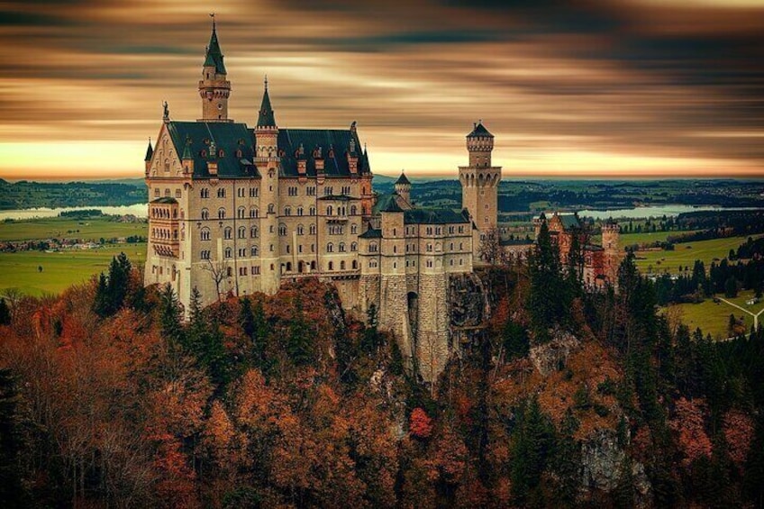 Un castillo rodeado de follaje otoñal y un cielo espectacular. 5