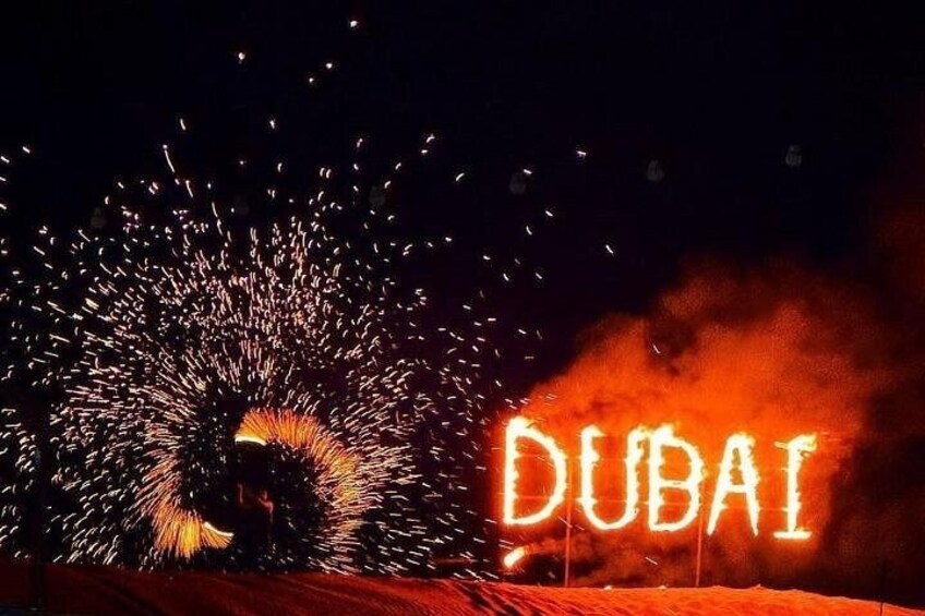 Vuurwerk met de tekst 'DUBAI' verlicht op de achtergrond. 3