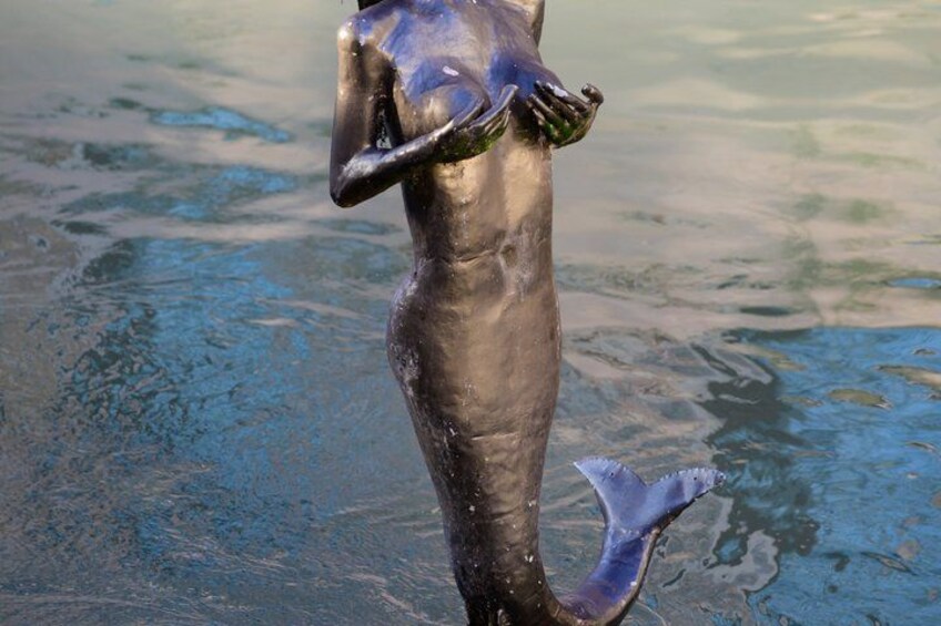A dolphin statue in water. 2