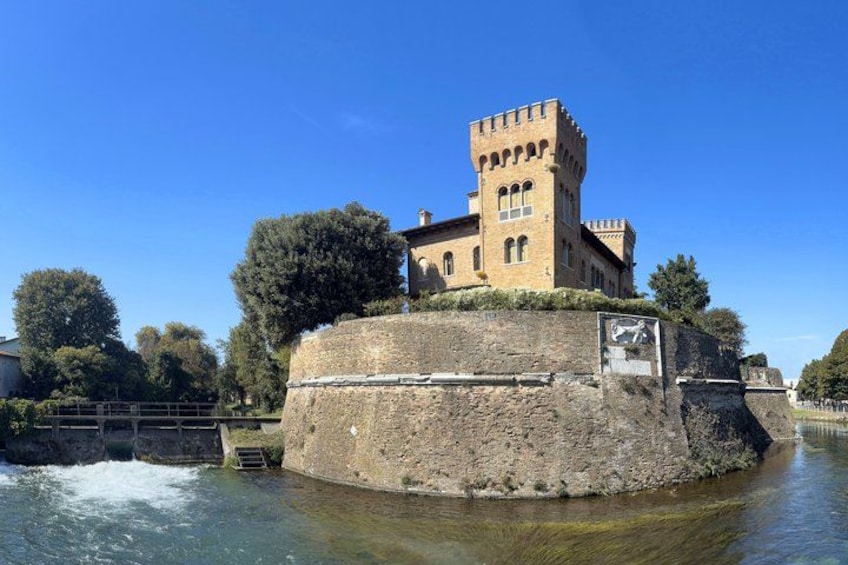 A historic stone building with a tower, situated on a round island in a river. 5