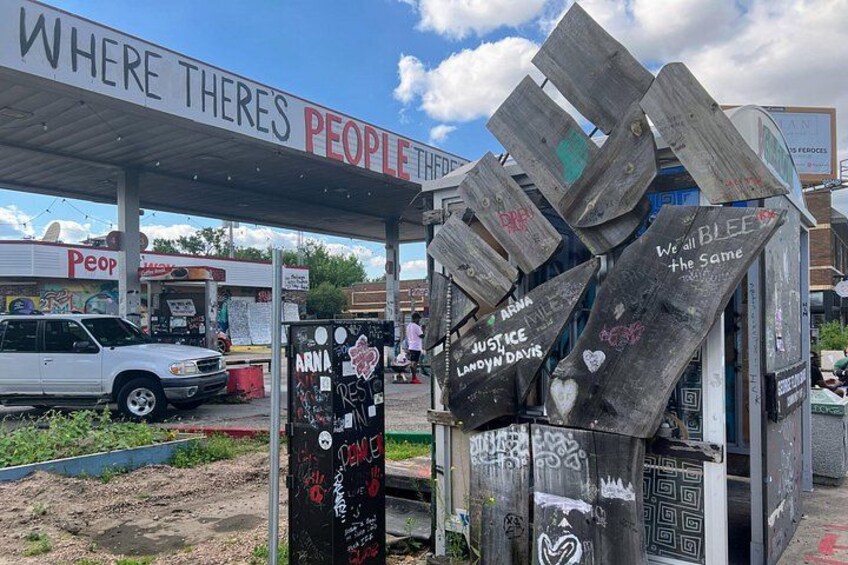 Una estación de servicio con un cartel que dice 'WHERE THERE'S PEOPLE'. 2