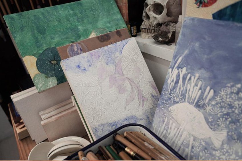 A collection of art supplies, including paintbrushes and canvases with various designs. 5