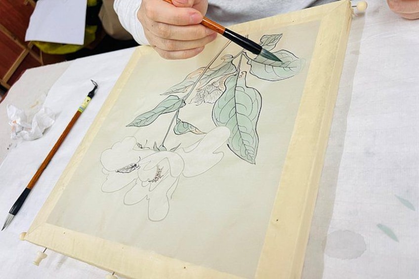 A person painting a floral design on a canvas. 2