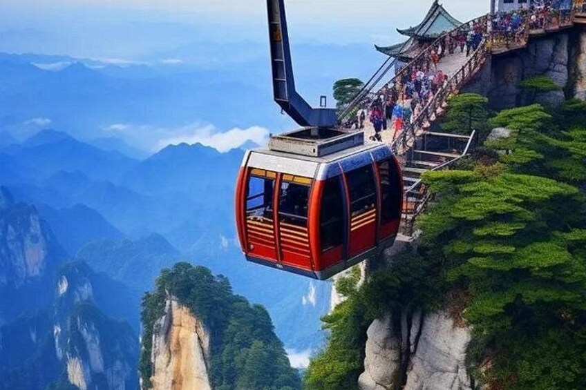 Une télécabine suspendue au-dessus d’un paysage montagneux, avec un bâtiment traditionnel et un escalier. 2