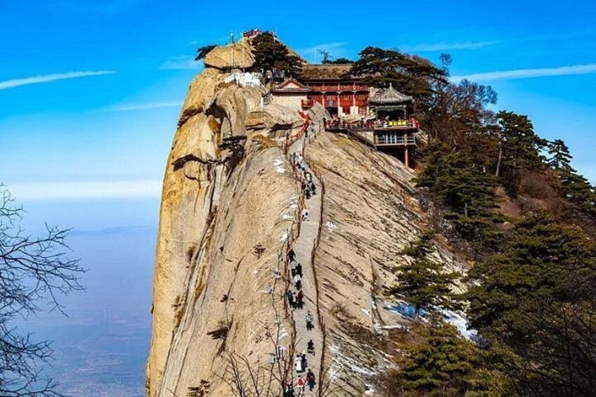 Une montagne escarpée, avec un long sentier qui mène à un temple situé au sommet. 3