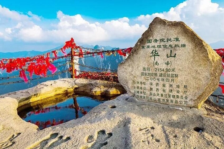 Un monument de pierre orné d’inscriptions, un ciel dégagé et un paysage montagneux. 5