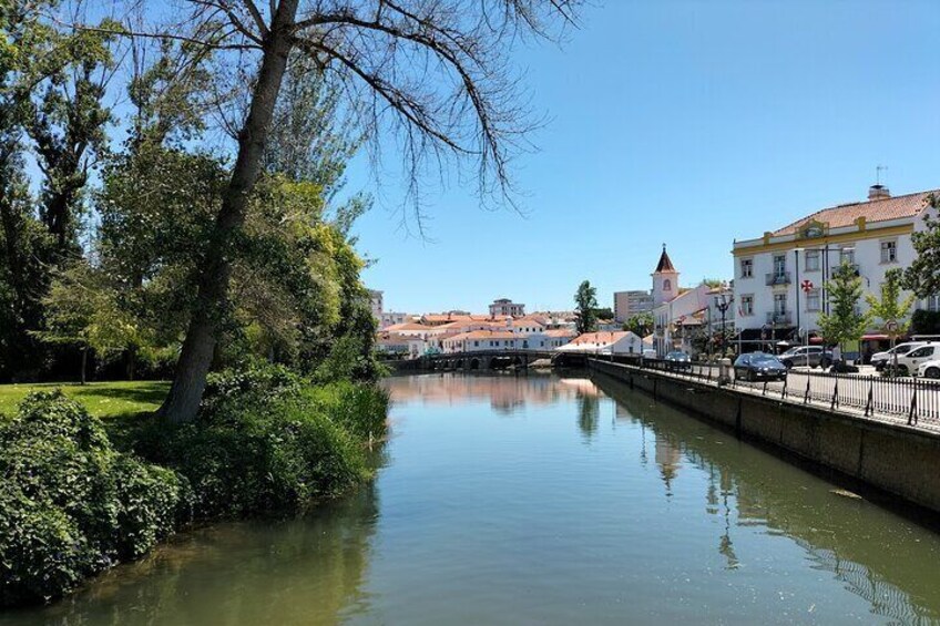 Ein ruhiger Fluss, eine Brücke und Gebäude entlang des Ufers. 2