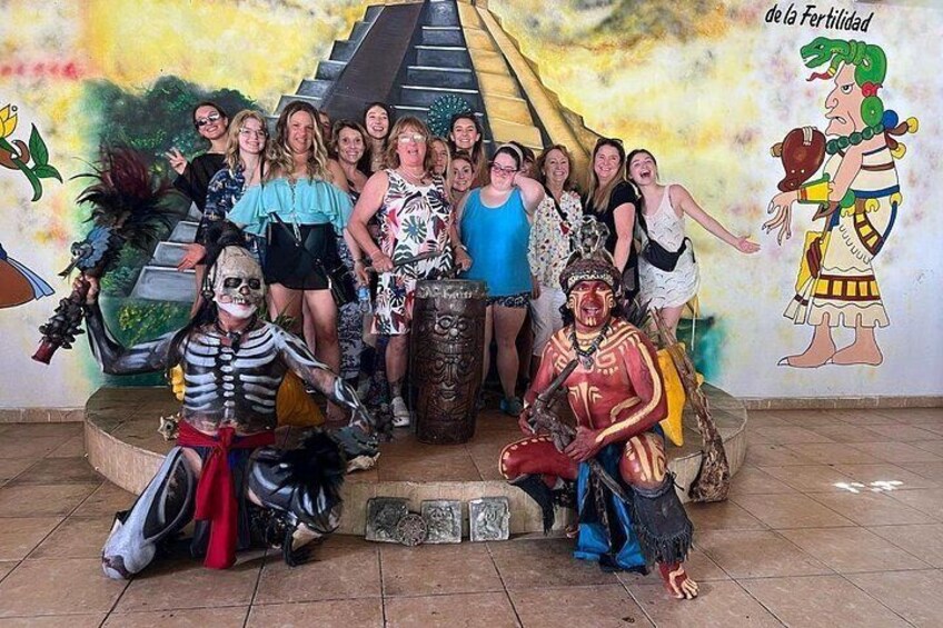 Un grupo de personas vestidas para una celebración, un mural y una escalera. 3