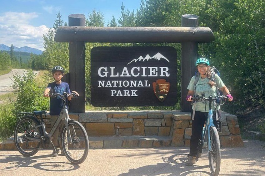 A sign for Glacier National Park with two bicycles in front. 4