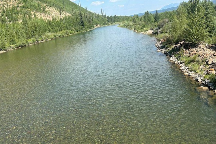 A river winding through a forested valley with mountains in the background. 2