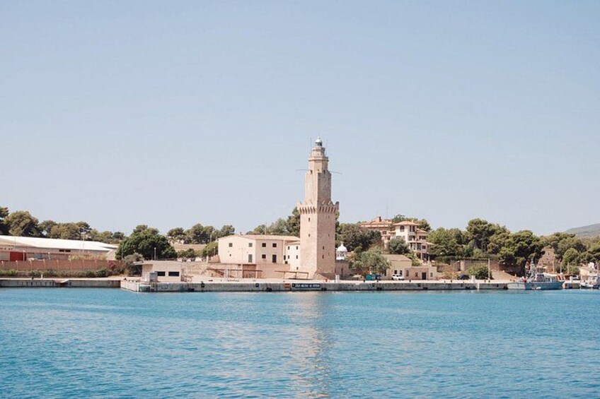Un pueblo costero con un faro destacado, aguas tranquilas y edificios circundantes. 4