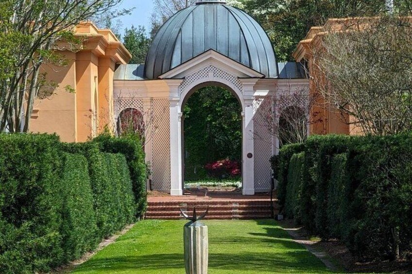 Un jardín con un pabellón, una estructura en forma de cúpula y setos bien recortados. 4