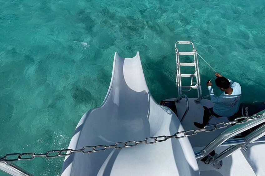 A person on a boat, a ladder, and clear turquoise water. 2