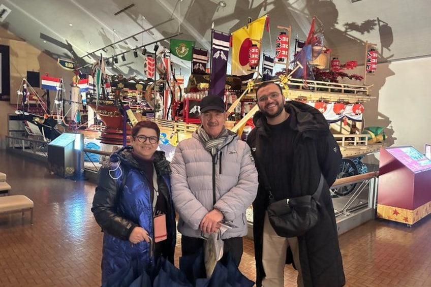 A group of people in a shopping area with various flags and a display of goods. 2