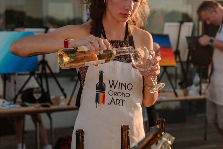 A person pouring wine into a glass. 5