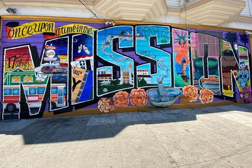 A colorful mural with the word 'MISSION' and various travel-related graphics. 3