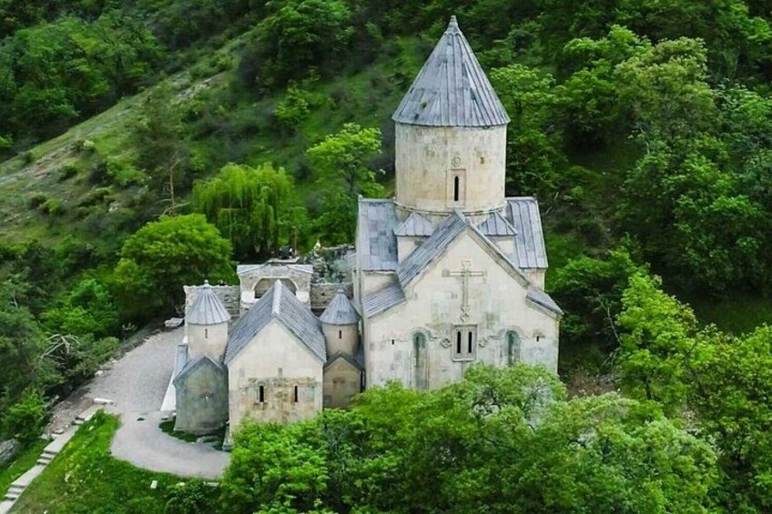 A church with a bell tower surrounded by lush greenery. 2