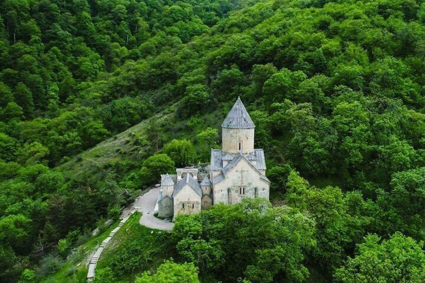 En kirke omgivet af tæt, grøn skov. 1