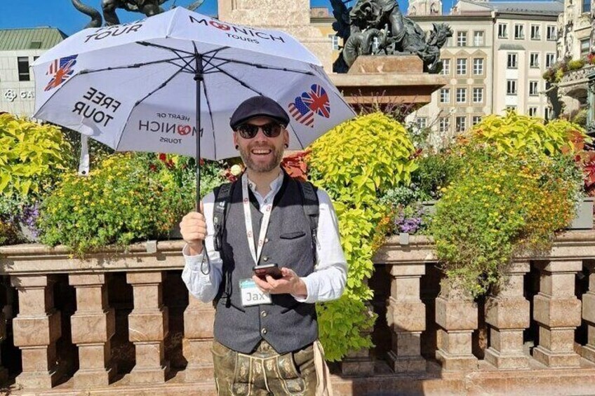 Eine Person hält einen Tour-Schirm vor einer Statue. 2