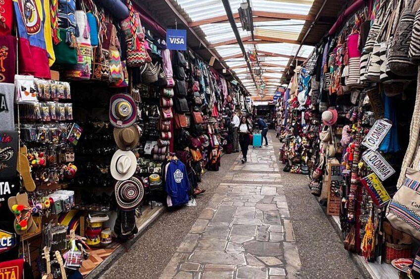 Un mercato con numerosi banchi che vendono cappelli, borse e altri accessori. 3