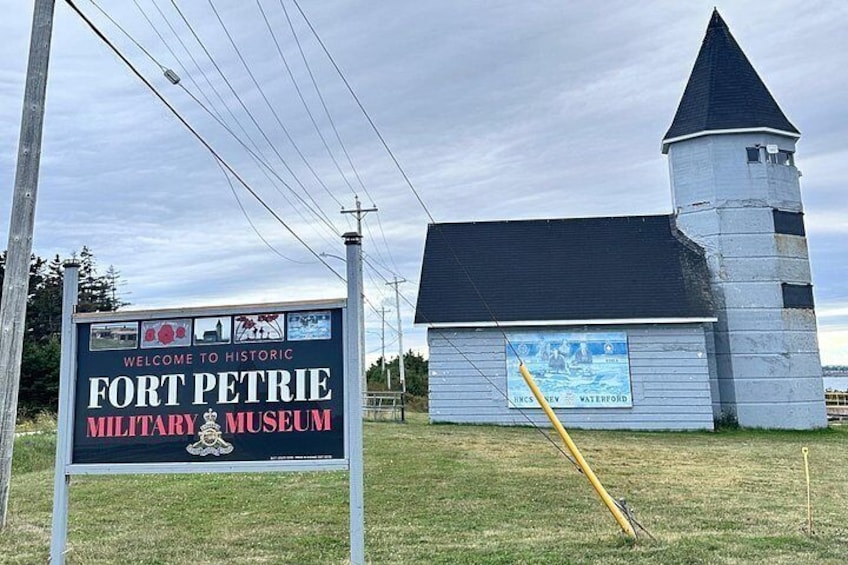 A historic military museum sign and a building with a tower. 4