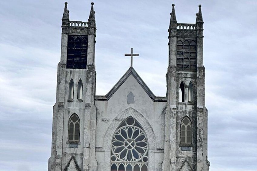 A Gothic-style church with two towers, a large rose window, and a cross at the top. 2