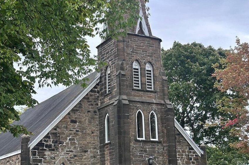 A stone church with a bell tower and arched windows. 3