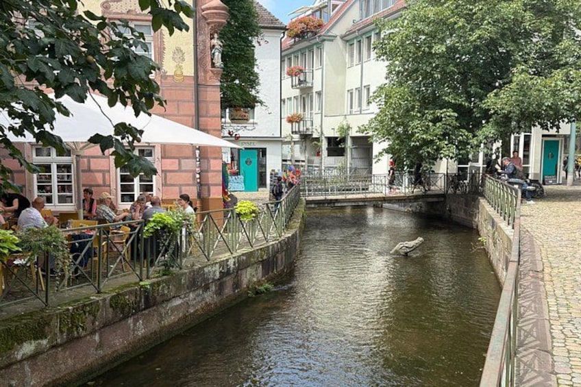 Un canale stretto con un ponte, edifici e persone. 5