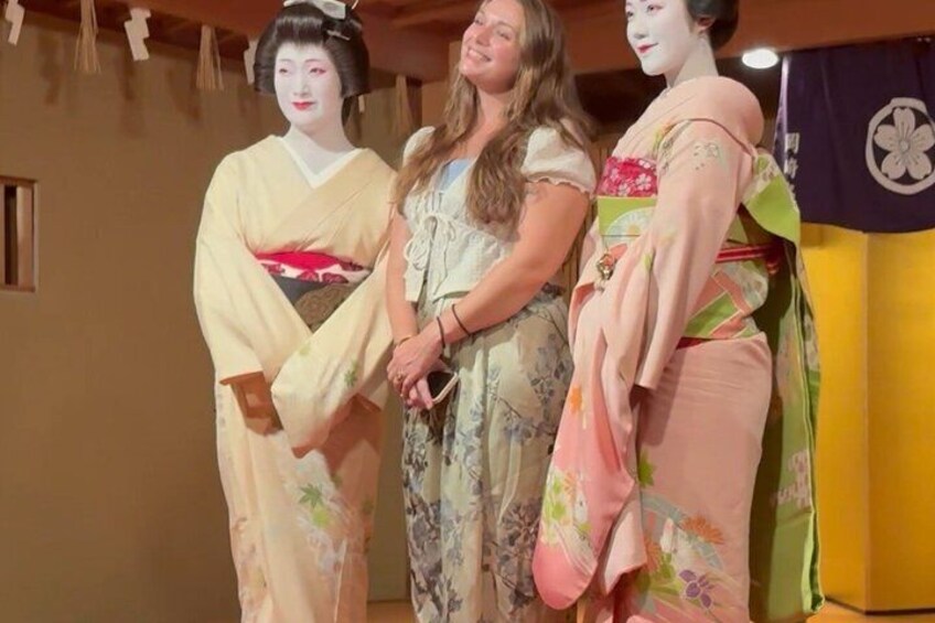 Three people standing in front of a traditional Japanese backdrop. 2