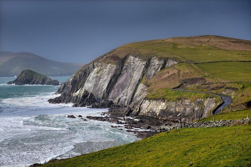 A coastal landscape with cliffs, a road, and the ocean. 3