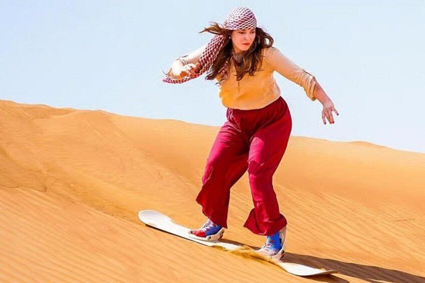 En person der snowboarder ned ad en sandklit. 3