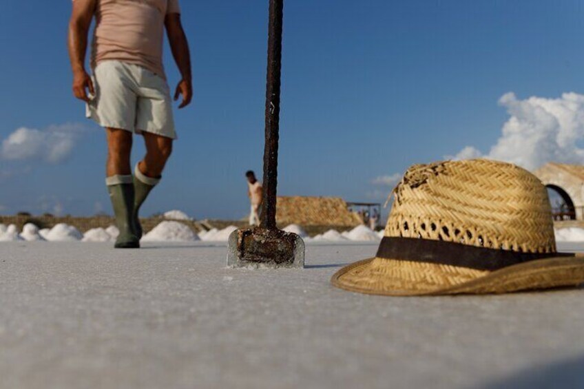 A straw hat on a concrete surface with a shovel nearby. 2